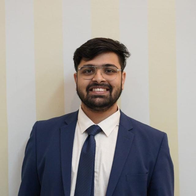 Creative writing objects on a table; pens, pencils, a sketch book, and a cup of coffee.